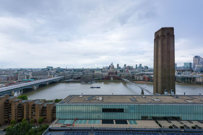 High angle view of buildings by river against sky