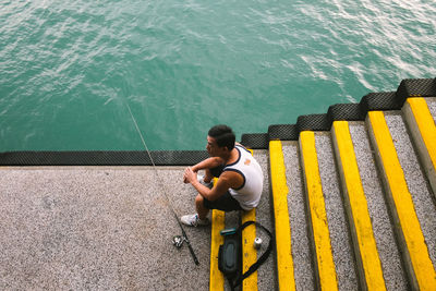 High angle view of man sitting on swimming pool