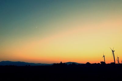 Scenic view of silhouette field against clear sky during sunset