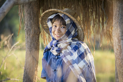 Portrait of girl sitting under shed at farm