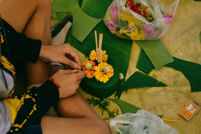 High angle view of woman sitting by religious offering