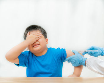 Boy looking away against wall at home