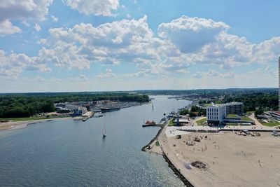 High angle view of city by sea against sky