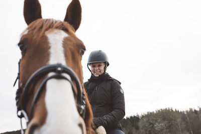 Smiling woman horseback riding