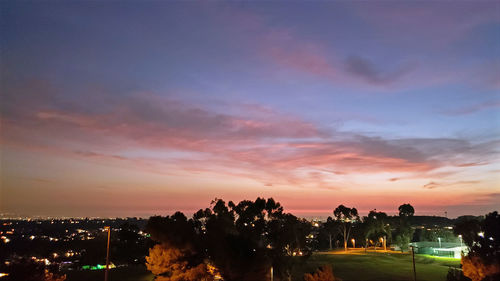 Illuminated buildings against sky at sunset