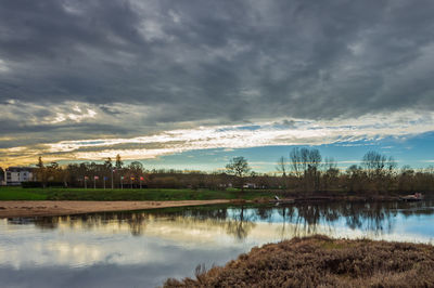 Scenic view of lake by buildings against sky