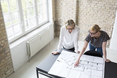 Mature businesswoman working with younger colleague in office