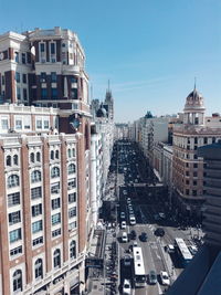 View of city street against clear blue sky