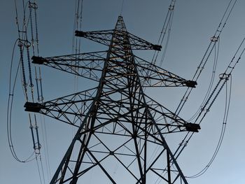 Low angle view of electricity pylon against sky