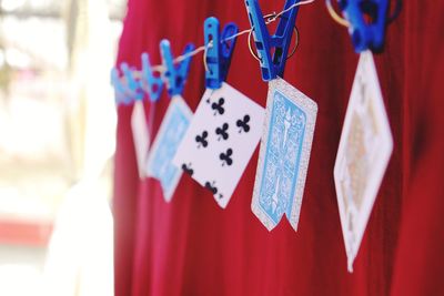 Close-up of playing cards hanging from clothespins