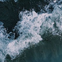 High angle view of waves splashing on rocks