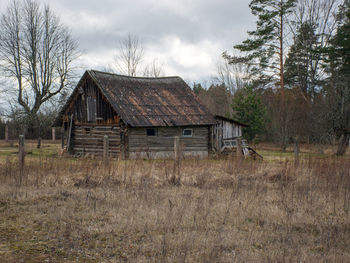 Landscape with an old wooden sauna, early spring, gray nature