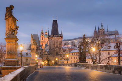 Illuminated buildings in city at dusk