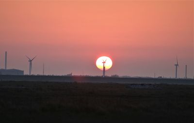 Windmill in the middle of the sun, during sunset.