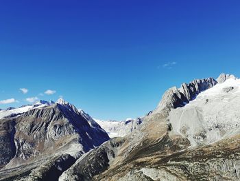 Scenic view of snowcapped mountains against blue sky