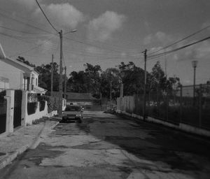 Cars on street in city against sky