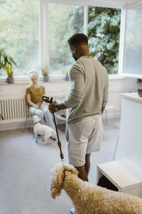 Young man walking with dog in waiting room of vet medical clinic