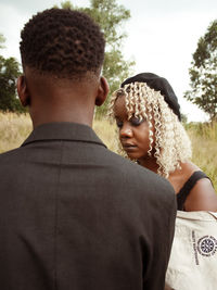 Side view of couple kissing against sky