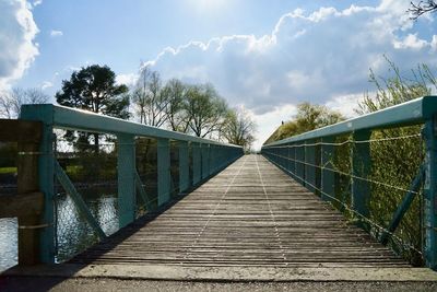 View of footbridge against cloudy sky