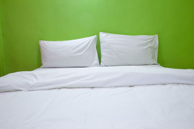 High angle view of pillows with sheet arranged on bed at home