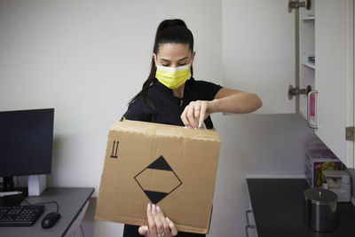 Female dentist in surgery opening cardboard box