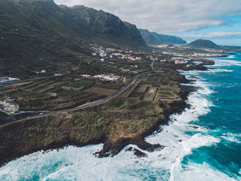 Scenic view of sea and mountains against sky