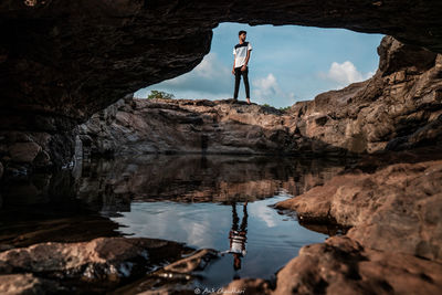 Man standing on rock by water