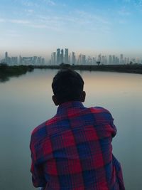 Rear view of man standing on river