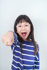 Portrait of smiling girl standing against white background
