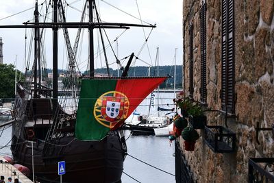 Sailboats moored at harbor against sky