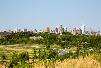 Trees and buildings against clear sky