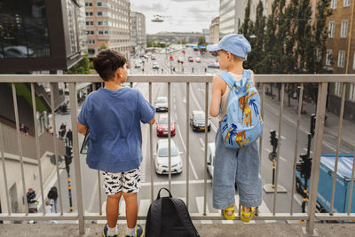 Children standing on viaduct and looking at traffic