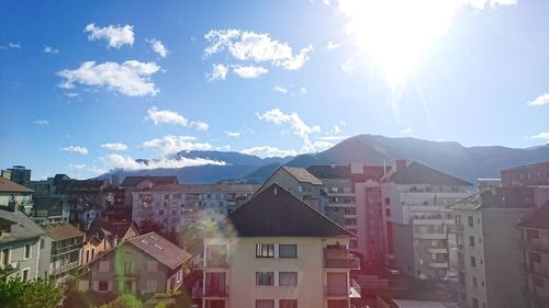 Buildings in town against sky on sunny day