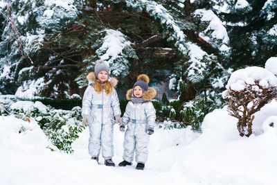 Two little cheerful children on snowy frosty day. brother and sister play