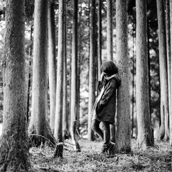 Man standing on tree trunk in forest