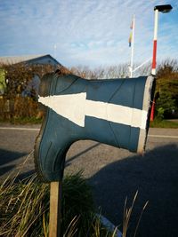 Close-up of flags on field by lake against sky