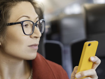 Woman in eyeglasses with smartphone. woman scrolls screen, reads news in social media or texting 