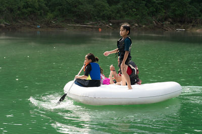 Family enjoying on pool raft over lake