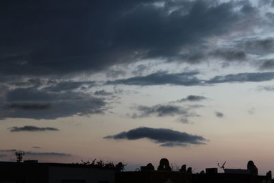 Silhouette of trees against cloudy sky