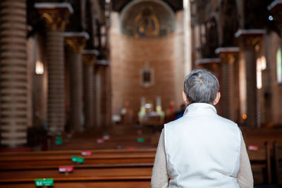Senior woman praying at the historical cathedral of our lady of poverty of pereira, built in 1890