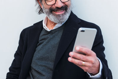 Man using mobile phone against wall
