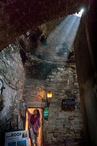 Woman hanging on wall in illuminated building