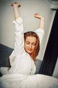 Young woman lying down on bed at home