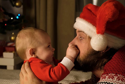 Father and little child have fun on christmas holidays. father in santa hat with baby at christmas.