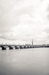 Pont de pierre bridge over river against cloudy sky