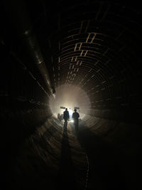 Rear view of man standing in tunnel