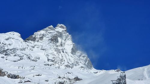 Scenic view of snowcapped mountains against blue sky