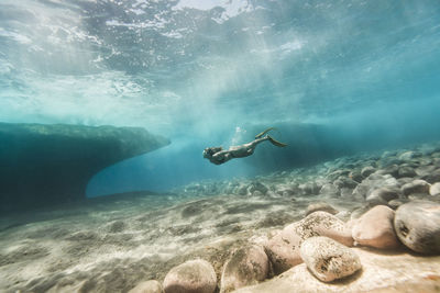 Side view of woman swimming undersea