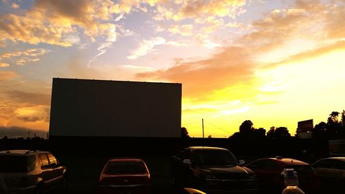 Cars parked on road at sunset