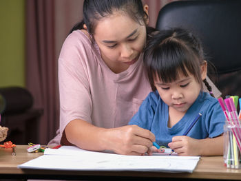 Mother teaching daughter at home